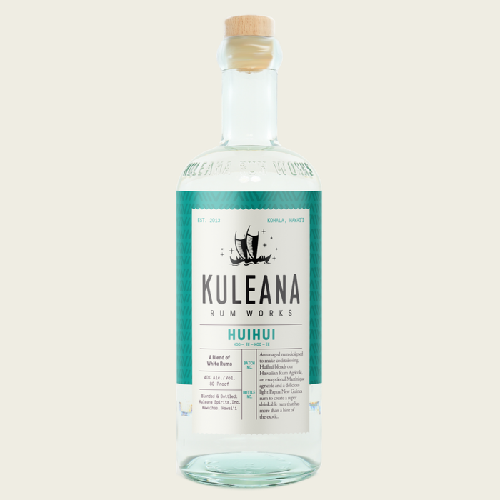 A bottle of Kuleana Rum Works Huihui rum on a solid light beige background. The bottle is made of clear glass, showing the liquid inside, and is sealed with a light wood cork.