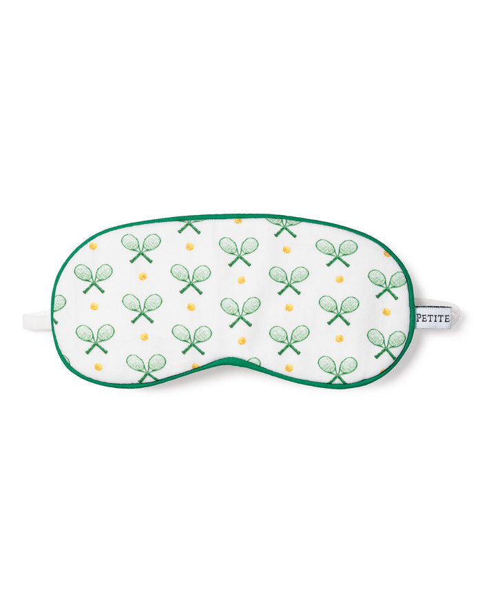 The Kids Sleep Mask in Match Point by Petite Plume features a white design with green racket and yellow ball prints. It includes an elastic strap labeled PETITE, ideal for tennis fans and a great match with tennis print pajamas.