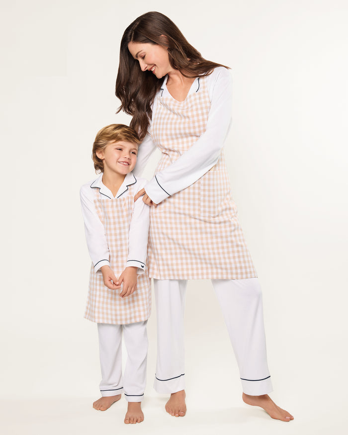 The Kid's Twill Apron in Camel Gingham, featuring a beige and white gingham pattern, two front pockets, and long waist ties, is displayed on a white background.