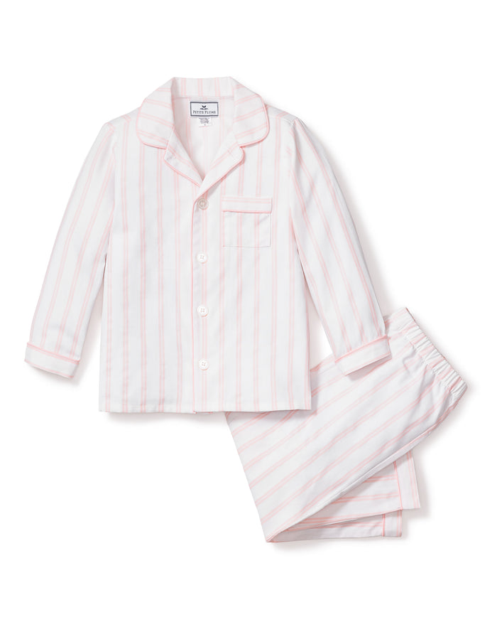 The Kids Twill Pajama Set by Petite Plume showcases luxurious pink and white stripes. The set features a long-sleeve button-up top with a chest pocket and matching pants, laid flat on a white background.