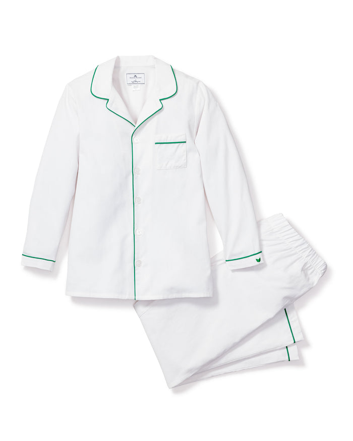 The Kids Twill Pajama Set by Petite Plume features a button-up long-sleeve shirt and pants in classic white, accented with green piping on the cuffs, collar, and pocket. Designed for comfort, it includes a left chest pocket. This flame-retardant sleepwear ensures peace of mind.