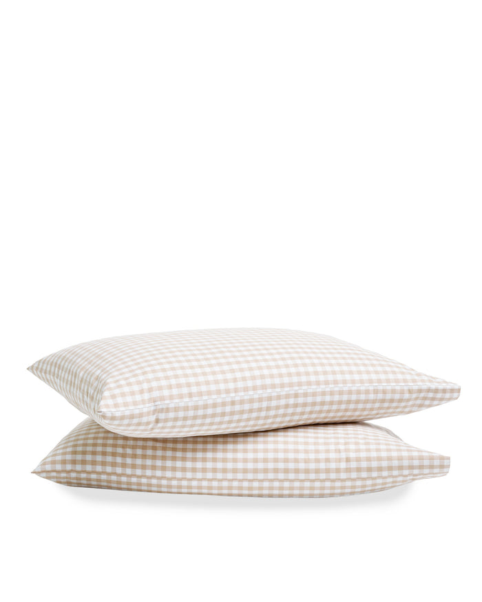 Two Luxe Premium Percale Pillow Cases in Camel Gingham, featuring a beige and white checkered design, are stacked on top of each other against a plain white background.