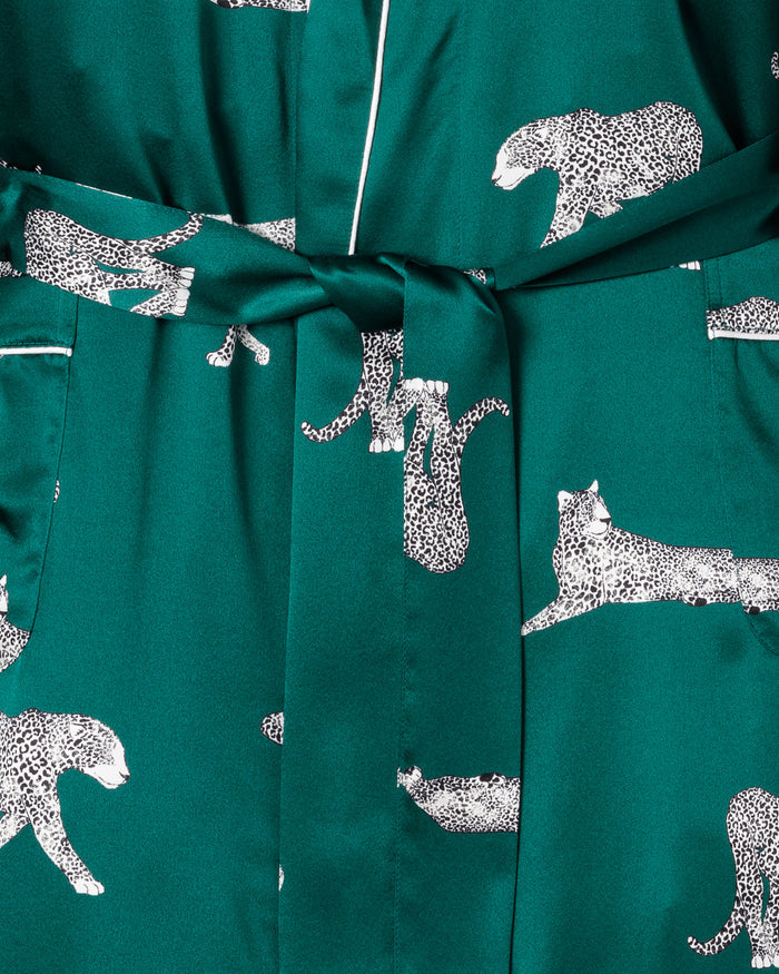 Close-up of the Mens Silk Long Robe in Panthère de Luxe by Petite Plume. This teal robe, adorned with leopard print, features a belt and two pockets. Made from luxurious Mulberry silk, it ensures ultimate comfort and style for lounging.