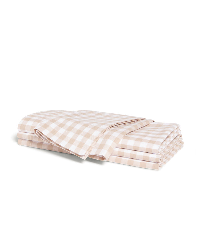 A neatly folded set of Signature Twill Napkins in a camel and white gingham checkered pattern, displayed on a white background.