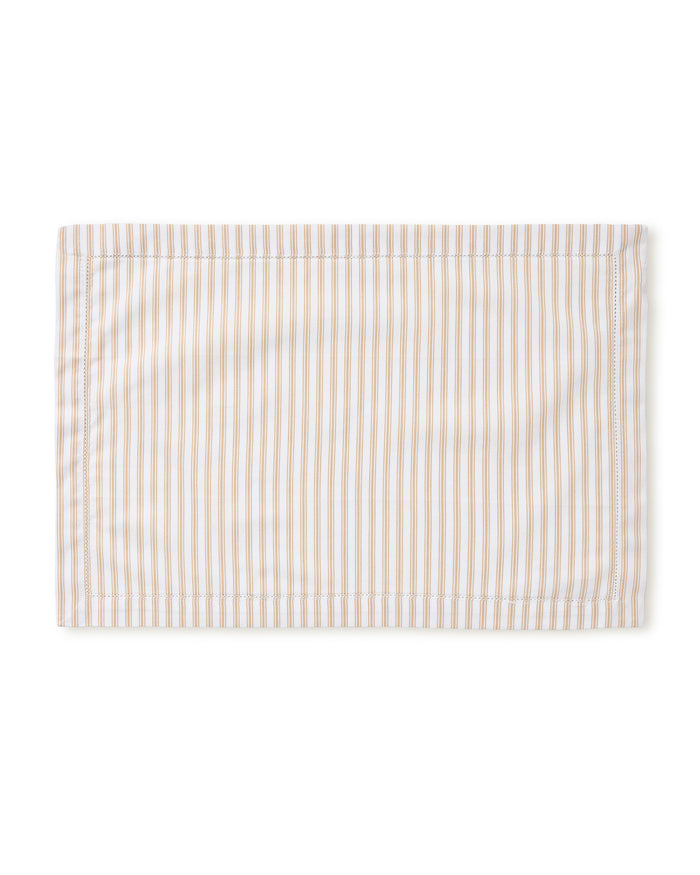 A Signature Twill Placemat in Camel Ticking, featuring light brown and white vertical stripes, is neatly laid flat on a white background.