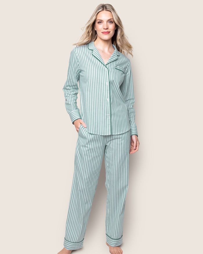 A stack of Petite Plumes Womens Twill Pajama Sets in Emerald Ticking showcases moisture-wicking fabric: the top has green clovers, the second is solid green, the third is white with green trim, and the bottom features bold green and white stripes.