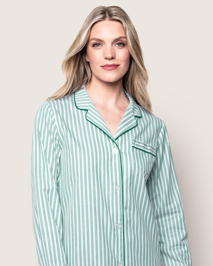 A stack of Petite Plumes Womens Twill Pajama Sets in Emerald Ticking showcases moisture-wicking fabric: the top has green clovers, the second is solid green, the third is white with green trim, and the bottom features bold green and white stripes.
